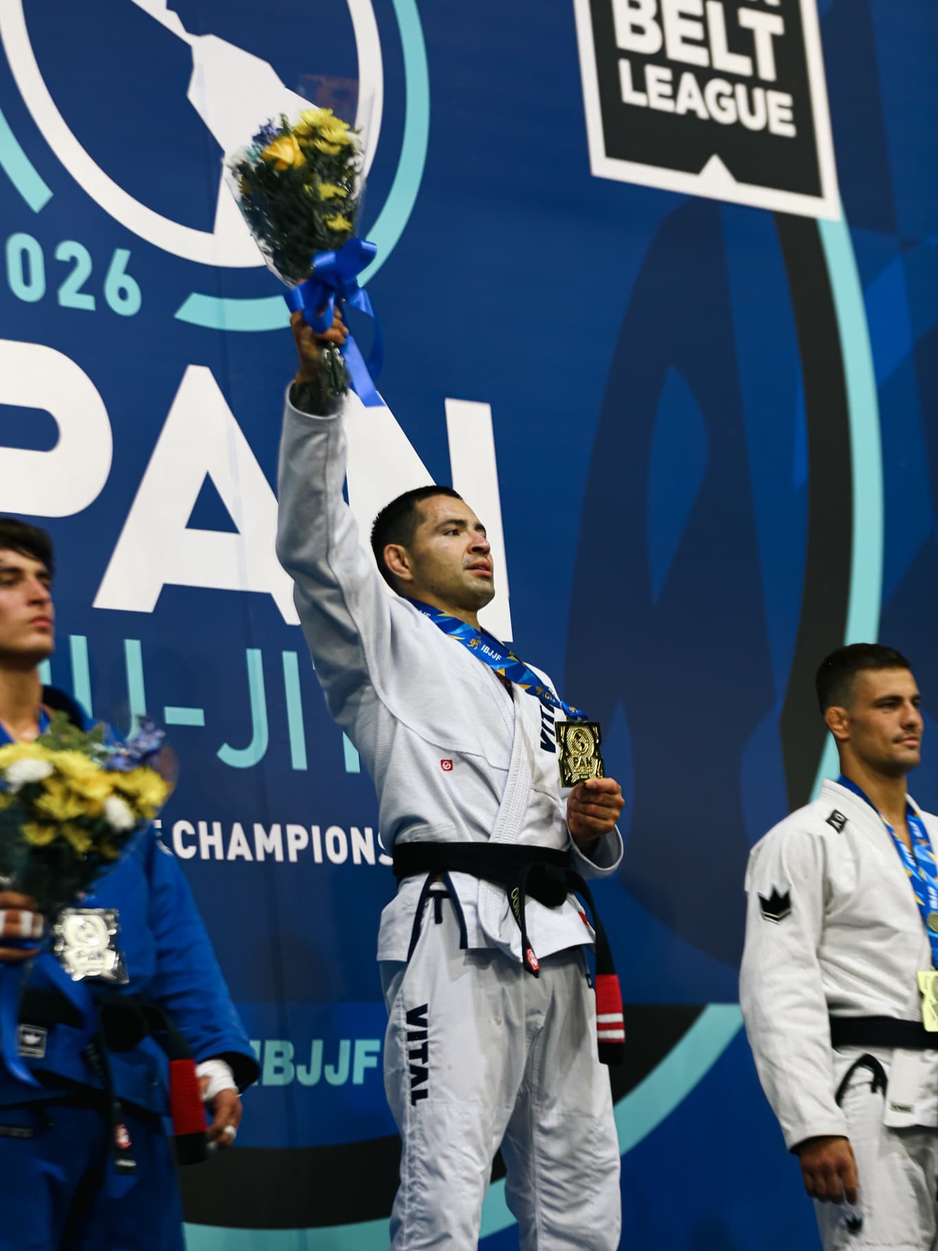 Gold medalist raising flowers on the podium