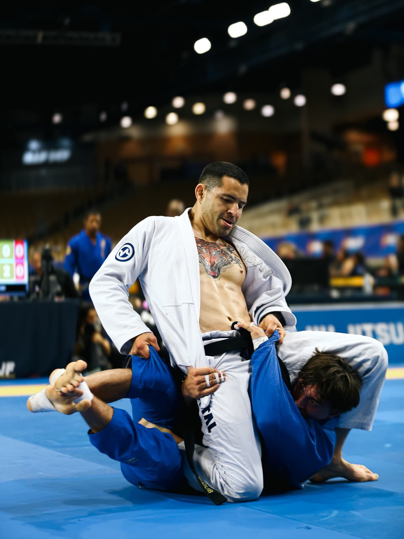 Black belt athlete working to pass the guard in a gi match